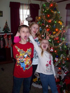 Kids doing their silly pose by the tree